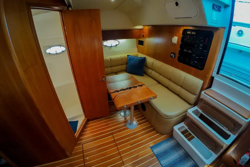 Slide: The Image of 1999 Tiara Yachts 3500 Express interior with wood finish, seating, and control panel. - 218