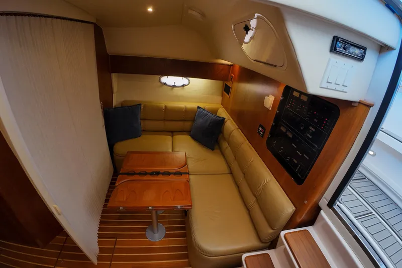 Slide: The Image of 1999 Tiara Yachts 3500 Express interior with cozy seating and wooden accents. - 222