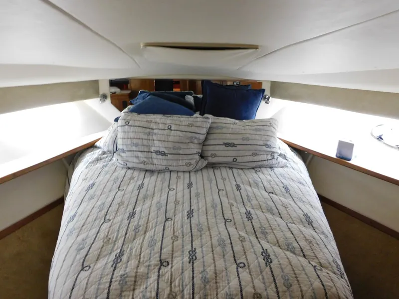Slide: The Image of 1999 Tiara Yachts 3500 Express cabin interior with cozy bed and nautical decor. - 26