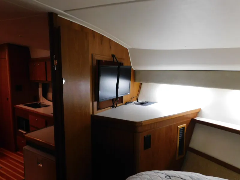 Slide: The Image of 1999 Tiara Yachts 3500 Express interior with wood cabinetry and mounted TV. - 27