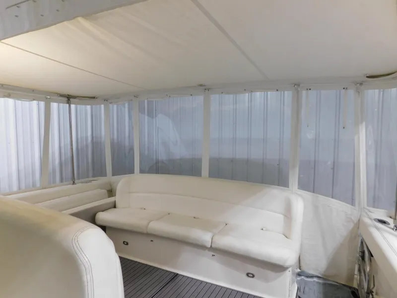 Slide: The Image of 1999 Tiara Yachts 3500 Express interior with white seating and enclosed cabin. - 36