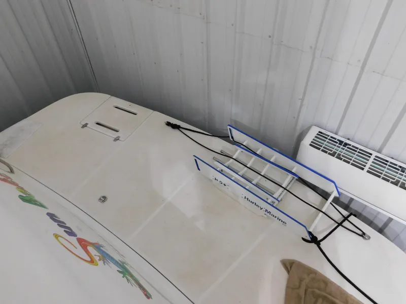 Slide: The Image of 1999 Tiara Yachts 3500 Express boat with ladder and colorful graphics in storage. - 37