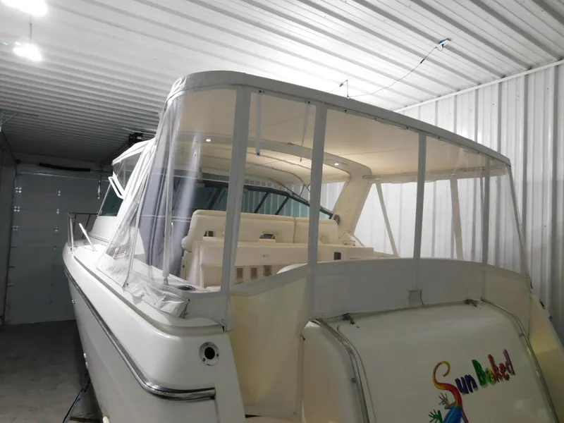 Slide: The Image of 1999 Tiara Yachts 3500 Express in storage, featuring a covered cockpit area. - 40