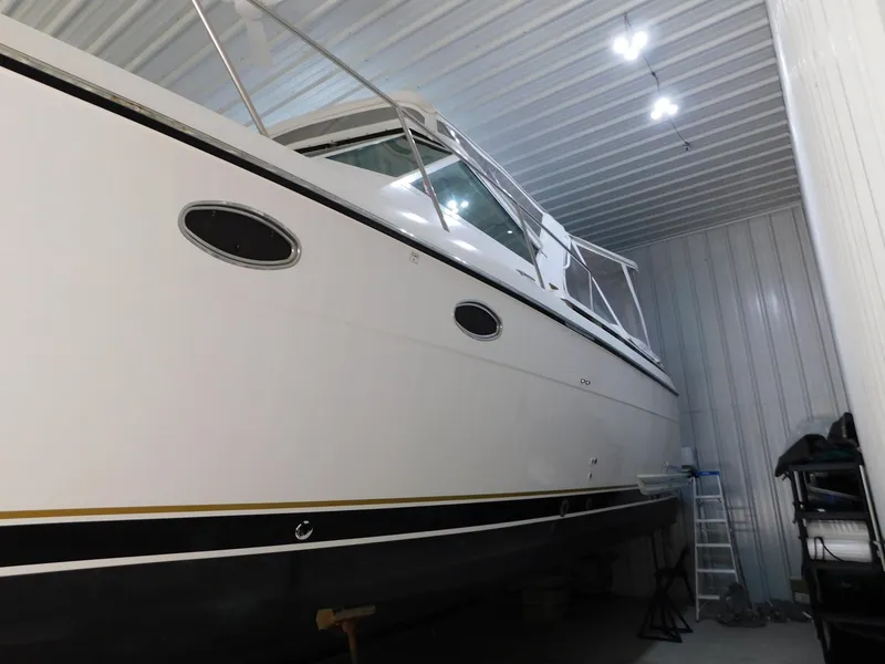 Slide: The Image of 1999 Tiara Yachts 3500 Express in storage, side view with sleek design. - 43
