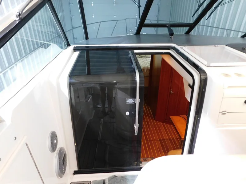 Slide: The Image of 1999 Tiara Yachts 3500 Express cabin entrance with glass door and wooden interior. - 6