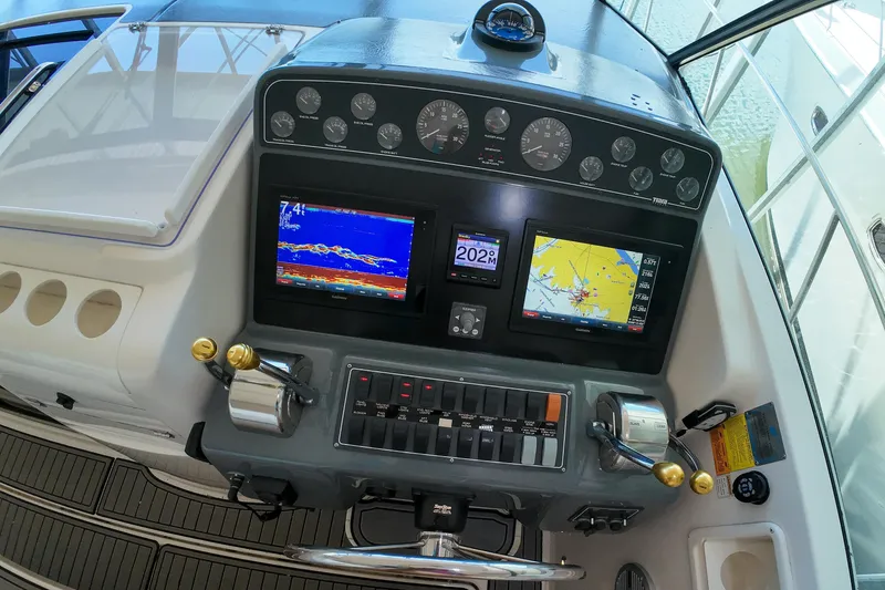 Slide: The Image of 1999 Tiara Yachts 3500 Express dashboard with navigation screens and controls. - 64