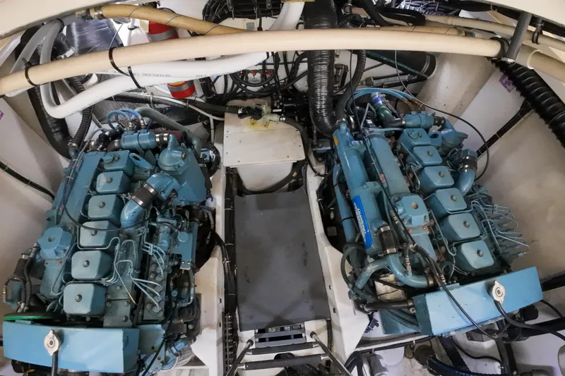 Slide: The Image of Engine room of a 1999 Tiara Yachts 3500 Express, featuring dual blue engines. - 66