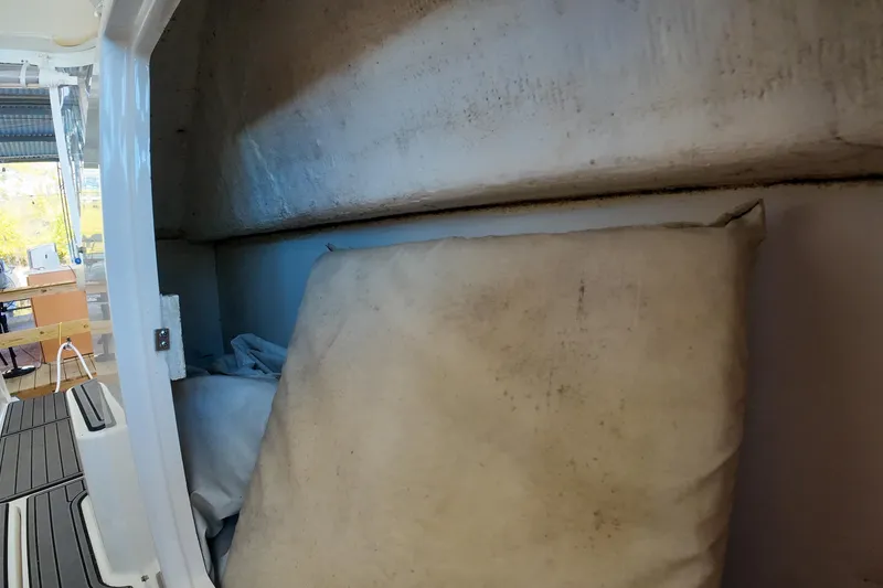 Slide: The Image of 1999 Tiara Yachts 3500 Express interior storage area with cushions and equipment. - 80