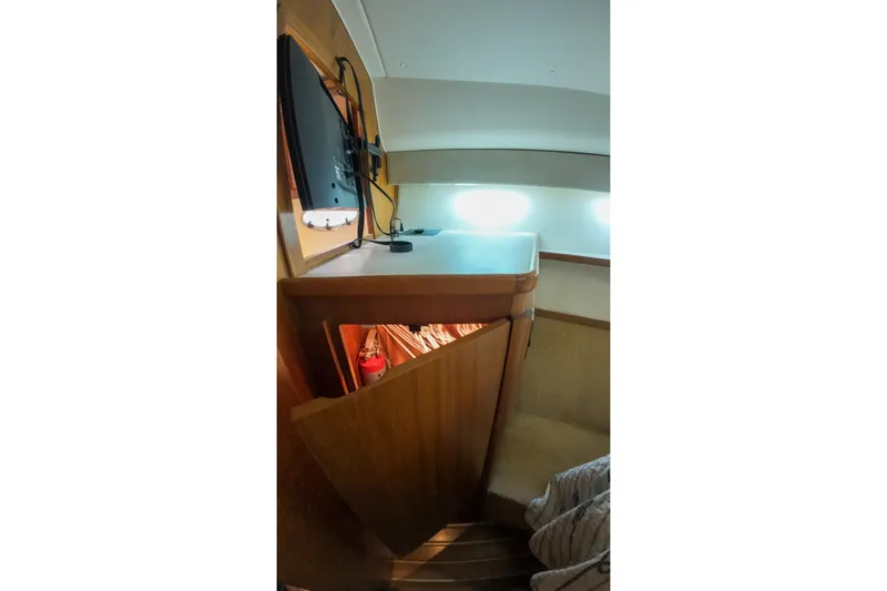 Slide: The Image of 1999 Tiara Yachts 3500 Express interior with wooden cabinetry and modern lighting. - 85