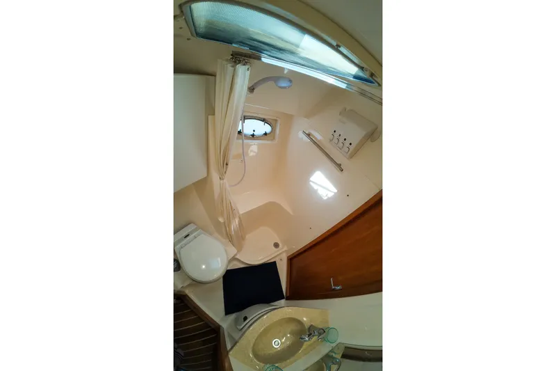 Slide: The Image of 1999 Tiara Yachts 3500 Express bathroom with shower, sink, and toilet. - 92