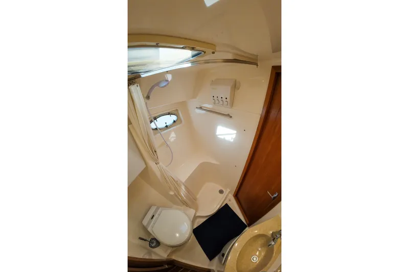 Slide: The Image of Bathroom interior of 1999 Tiara Yachts 3500 Express, featuring shower, toilet, and sink. - 94