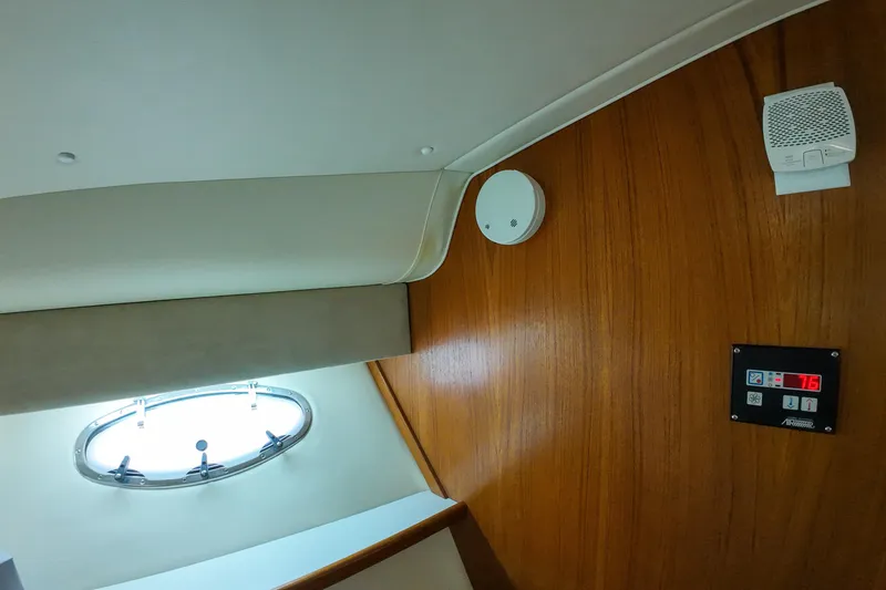 Slide: The Image of Interior of 1999 Tiara Yachts 3500 Express with wood paneling and porthole window. - 96