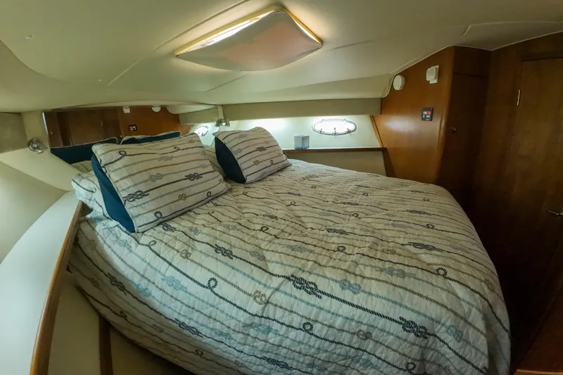 Slide: The Image of 1999 Tiara Yachts 3500 Express cabin with cozy bed and nautical-themed bedding. - 97