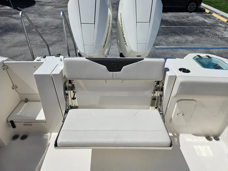 Slide: The Image of 2024 Sailfish 312CC boat with fold-down transom seat and twin outboard engines. - 10