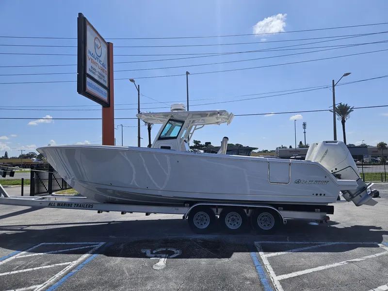 Slide: The Image of 2024 Sailfish 312CC boat on a trailer in a parking lot. - 2