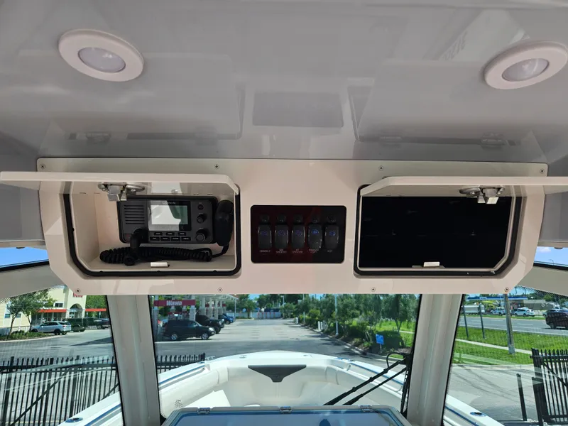 Slide: The Image of 2024 Sailfish 312CC boat console with electronic equipment and storage compartments. - 23