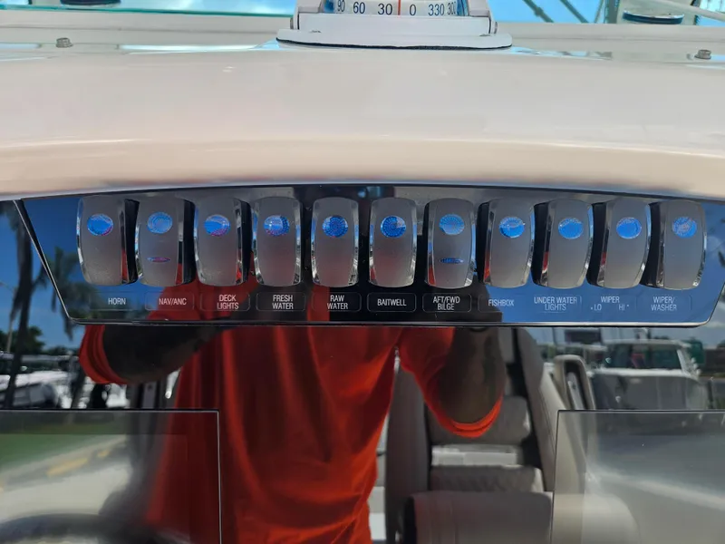 Slide: The Image of Control panel of a 2024 Sailfish 312CC boat with various switches. - 27