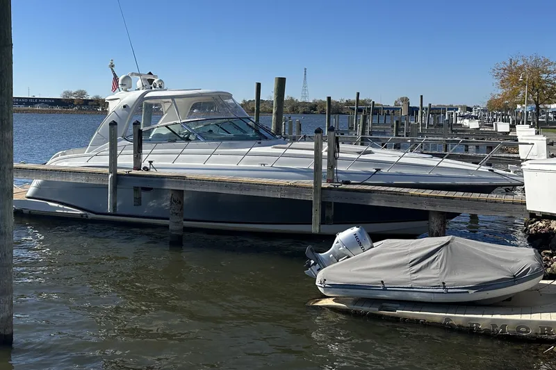 Slide: The Image of 2004 Formula 48 Yacht docked at marina with covered boat nearby. - 2