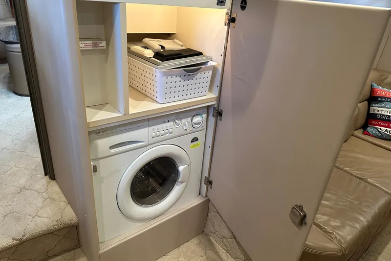 Slide: The Image of Laundry area inside a 2004 Formula 48 Yacht with washer and storage shelves. - 26
