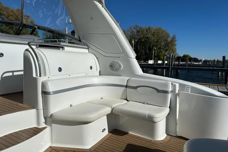 Slide: The Image of 2004 Formula 48 Yacht interior with white seating, docked by a serene waterfront. - 29