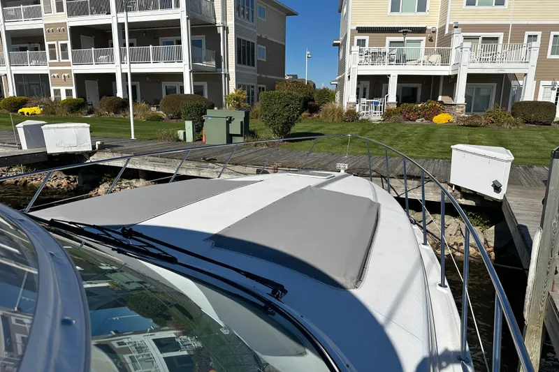 Slide: The Image of 2004 Formula 48 Yacht docked near waterfront homes on a sunny day. - 49