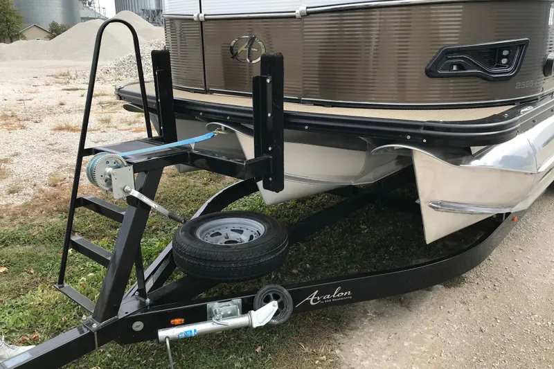 Slide: The Image of 2019 Avalon Catalina VRL 25' boat on trailer, featuring a winch and spare tire. - 5