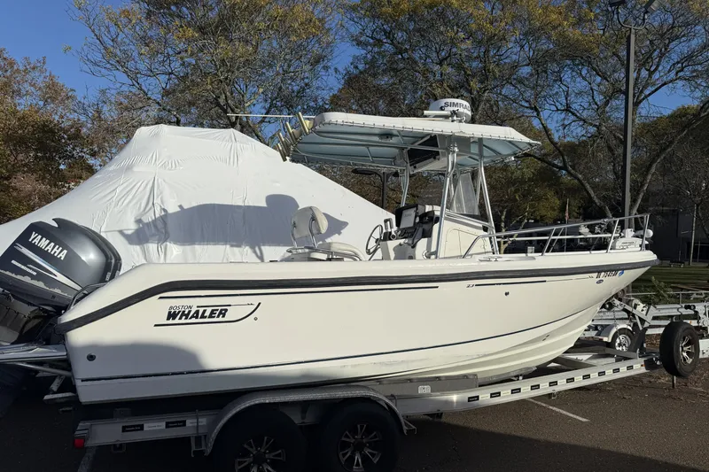 Slide: The Image of 2001 Boston Whaler 230 Outrage boat on trailer with Yamaha engine, parked outdoors. - 1
