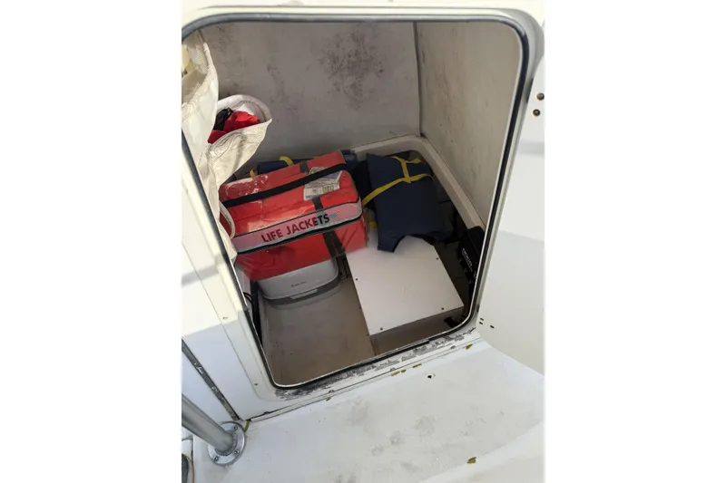 Slide: The Image of Storage compartment on 2001 Boston Whaler 230 Outrage with life jackets and equipment. - 7