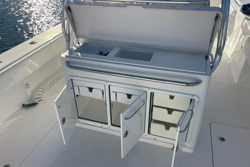 Slide: The Image of 2018 Southport 33 FE boat with open storage compartments and sleek design. - 23