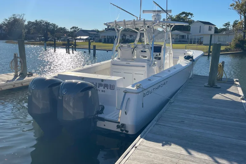 Slide: The Image of 2018 Southport 33 FE boat docked, featuring dual outboard motors. - 3