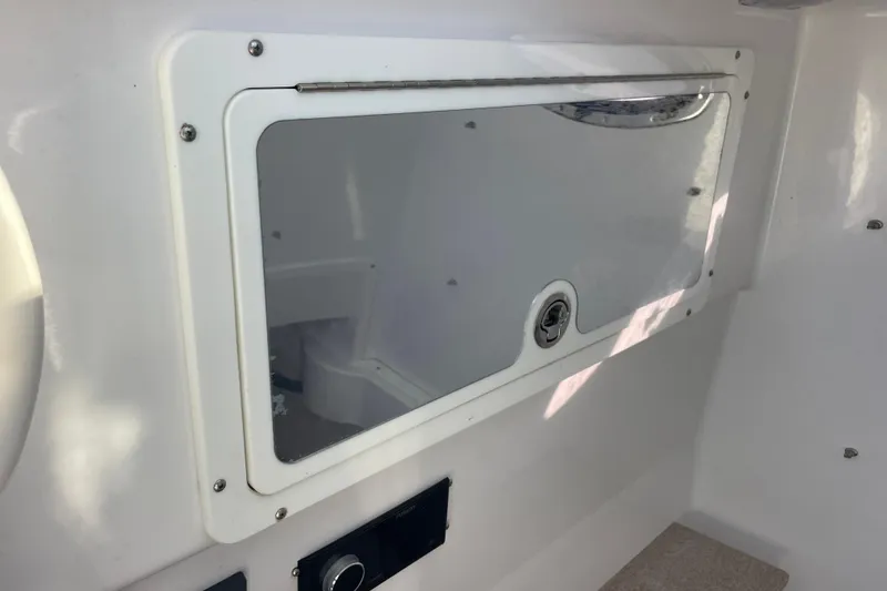 Slide: The Image of 2018 Southport 33 FE boat interior storage compartment with latch and control panel. - 45