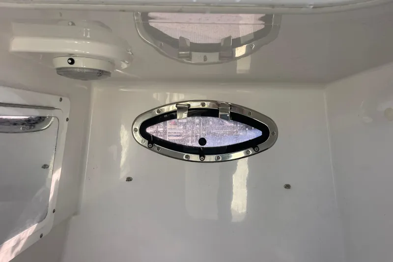 Slide: The Image of 2018 Southport 33 FE boat interior with oval porthole and ceiling light. - 46