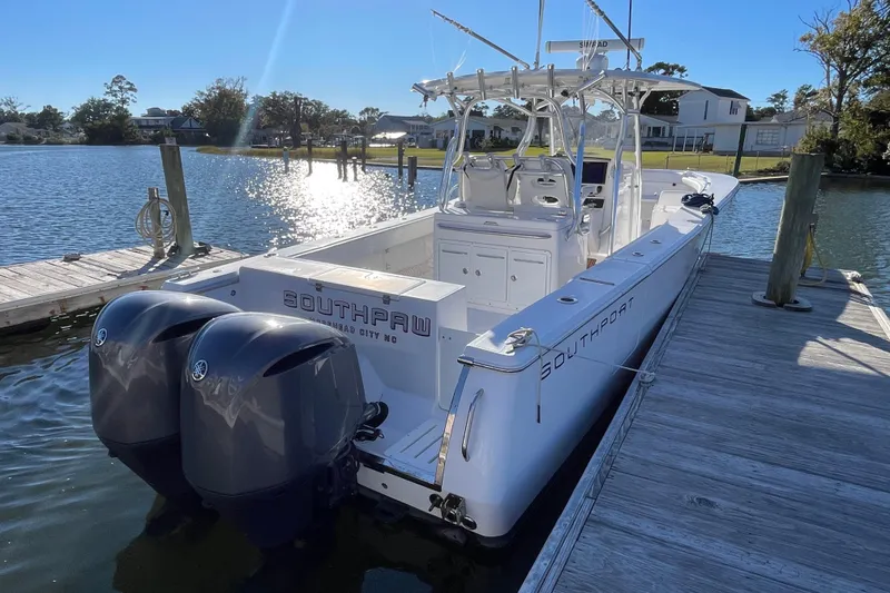 Slide: The Image of 2018 Southport 33 FE boat docked with dual outboard engines on a sunny day. - 5