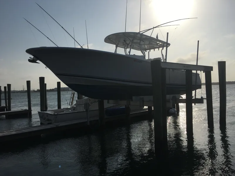Slide: The Image of 2018 Southport 33 FE boat on lift at marina, silhouetted against sunset. - 50