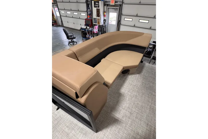 Slide: The Image of 2026 Lowe LS 170 boat interior with tan and black seating in a garage setting. - 10
