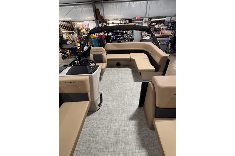 Slide: The Image of 2026 Lowe LS 170 boat interior with beige seating in a showroom. - 12