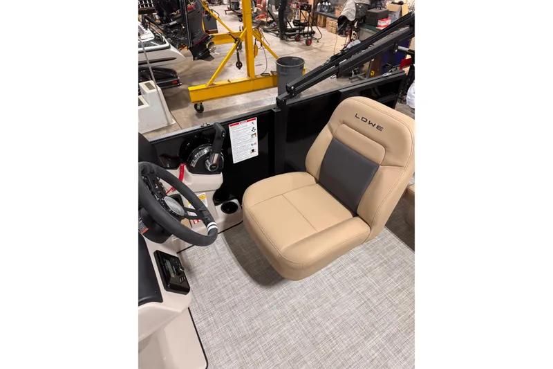 Slide: The Image of Lowe LS 170 boat interior with beige captain's chair and steering wheel, 2026 model. - 8