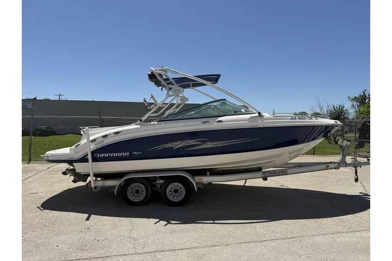 The Image of 2007 Chaparral 236 SSX boat on trailer, blue and white design, parked outdoors. - 0
