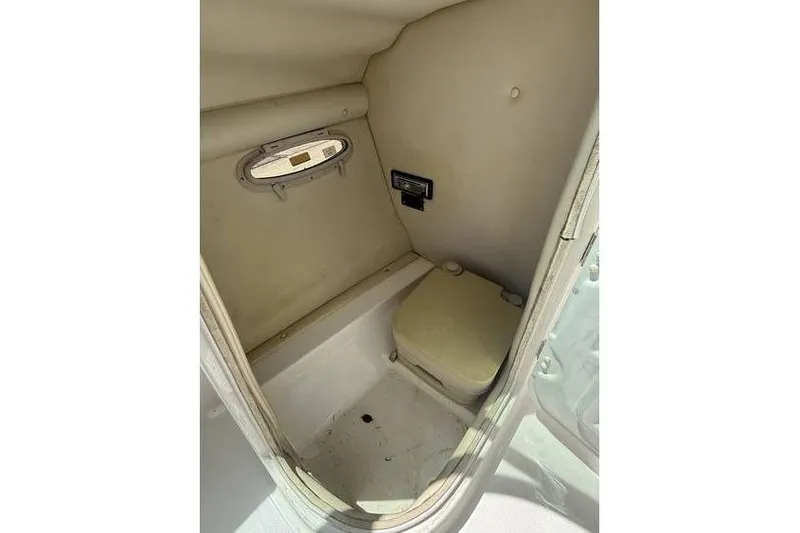 Slide: The Image of 2007 Chaparral 236 SSX boat interior with compact toilet and small window. - 6