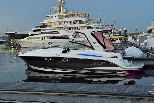Slide: The Image of 2021 Monterey 335 Sport Yacht docked in a marina, surrounded by luxury boats. - 0