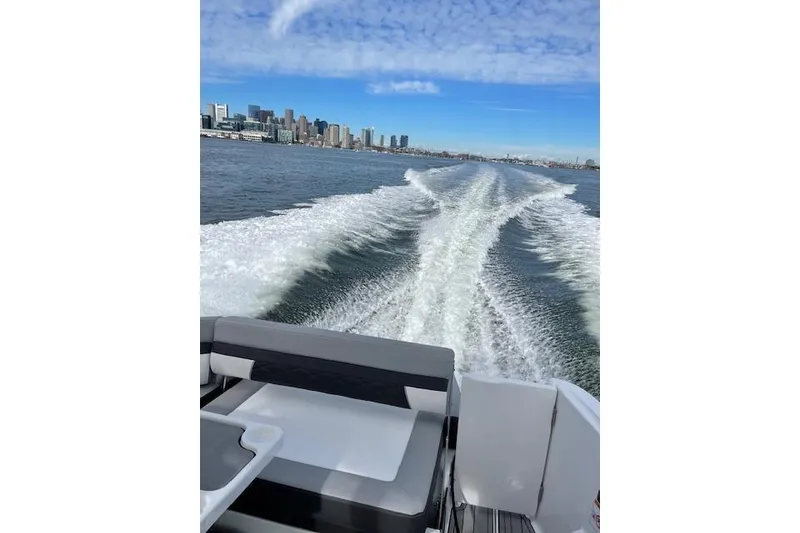 Slide: The Image of 2021 Monterey 335 Sport Yacht cruising with city skyline in background. - 18