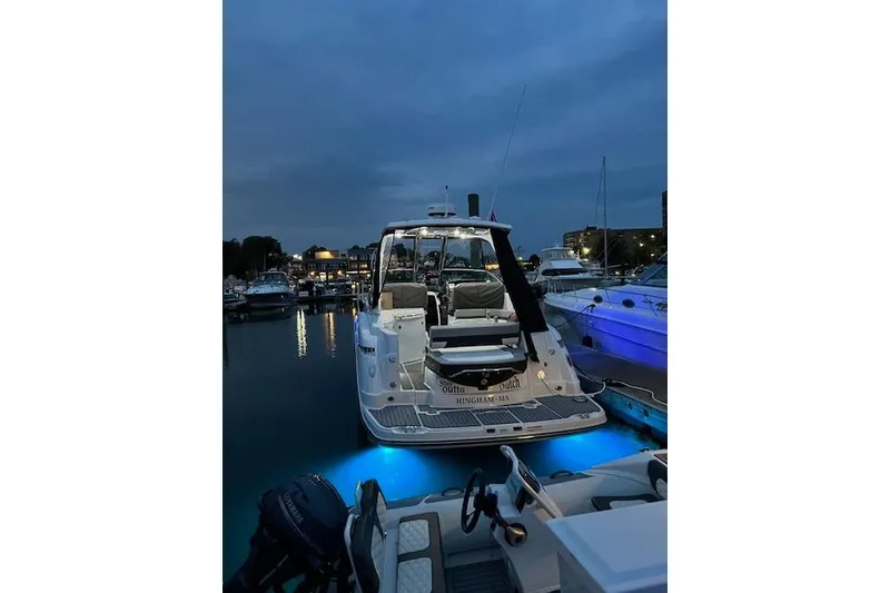 Slide: The Image of 2021 Monterey 335 Sport Yacht docked at night with blue underwater lights. - 2
