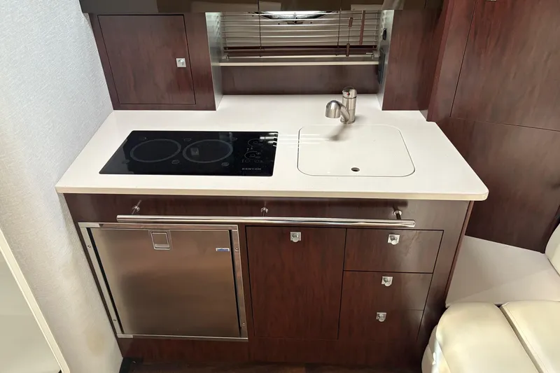 Slide: The Image of Modern kitchenette in 2021 Monterey 335 Sport Yacht with stove, sink, and storage. - 27