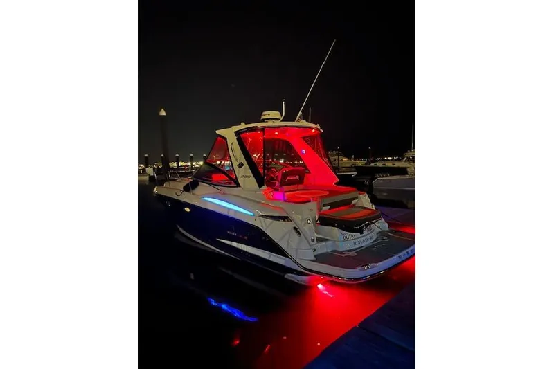 Slide: The Image of 2021 Monterey 335 Sport Yacht illuminated at night with red and blue lights. - 9