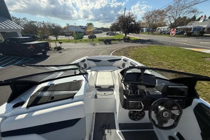 Slide: The Image of 2022 Axis A24 boat interior with modern dashboard and seating, parked outdoors. - 5