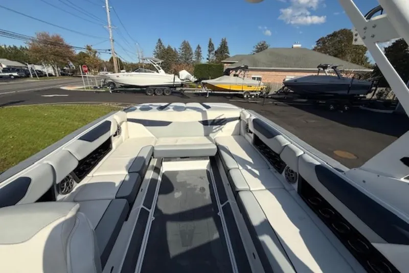 Slide: The Image of 2022 Axis A24 boat interior with spacious seating, parked outdoors under clear sky. - 6