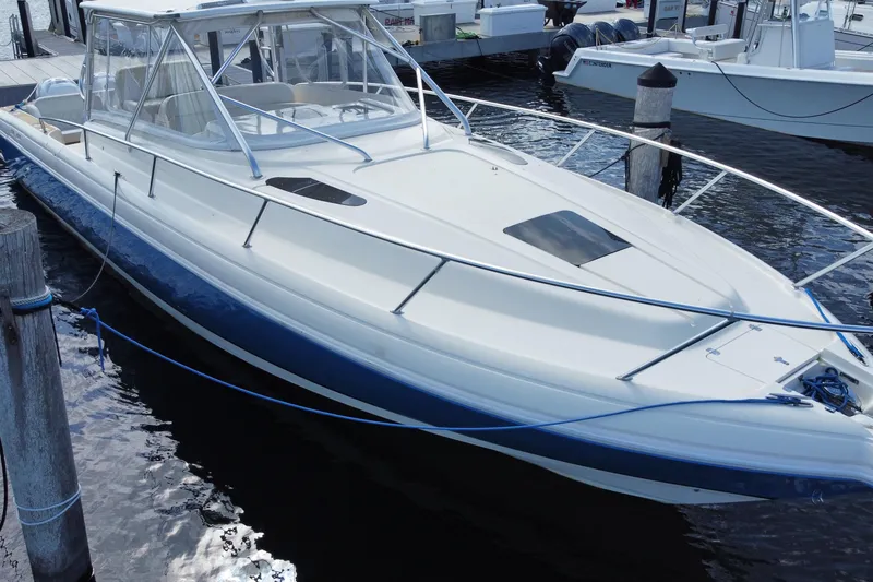 Slide: The Image of 2006 Intrepid 377 boat docked at marina, featuring sleek design and blue accents. - 11