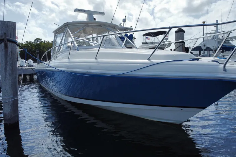 Slide: The Image of 2006 Intrepid 377 boat docked in marina, featuring sleek blue and white design. - 12