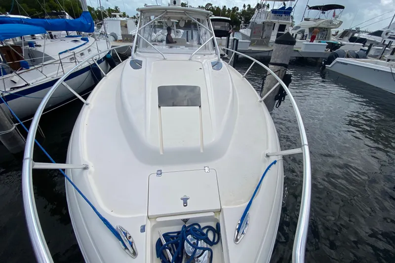 Slide: The Image of 2006 Intrepid 377 boat docked at marina, featuring sleek white deck and blue ropes. - 17