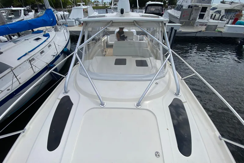 Slide: The Image of 2006 Intrepid 377 boat docked, featuring sleek design and spacious deck area. - 18